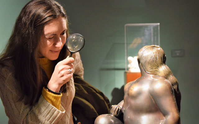 Joven observando una escultura de Fernando Botero