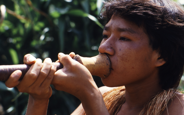 Indígena del Amazonas tocando flauta
