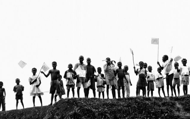Niños saludando con banderas de paz.