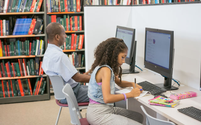 Niña haciendo tareas frente a un computador de la Biblioteca del Centro Cultural del Banco de la República de Buenaventura.