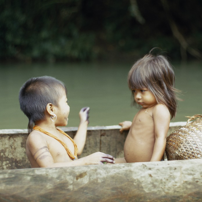 Niños embera en una embarcación. Uno de ellos usa los adornos tradicionales de su comunidad. 