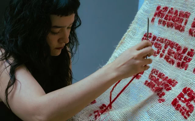 En la foto se puede observar a la artista Daniela Sánchez trabajando en su obra