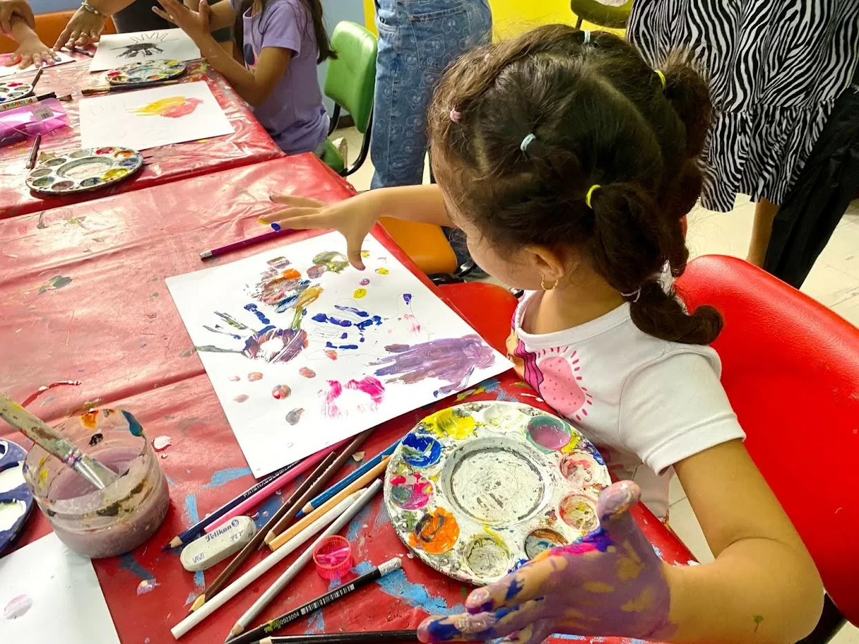 Una niña pintando con las manos en la sala infantil del Centro Cultural de Santa Marta