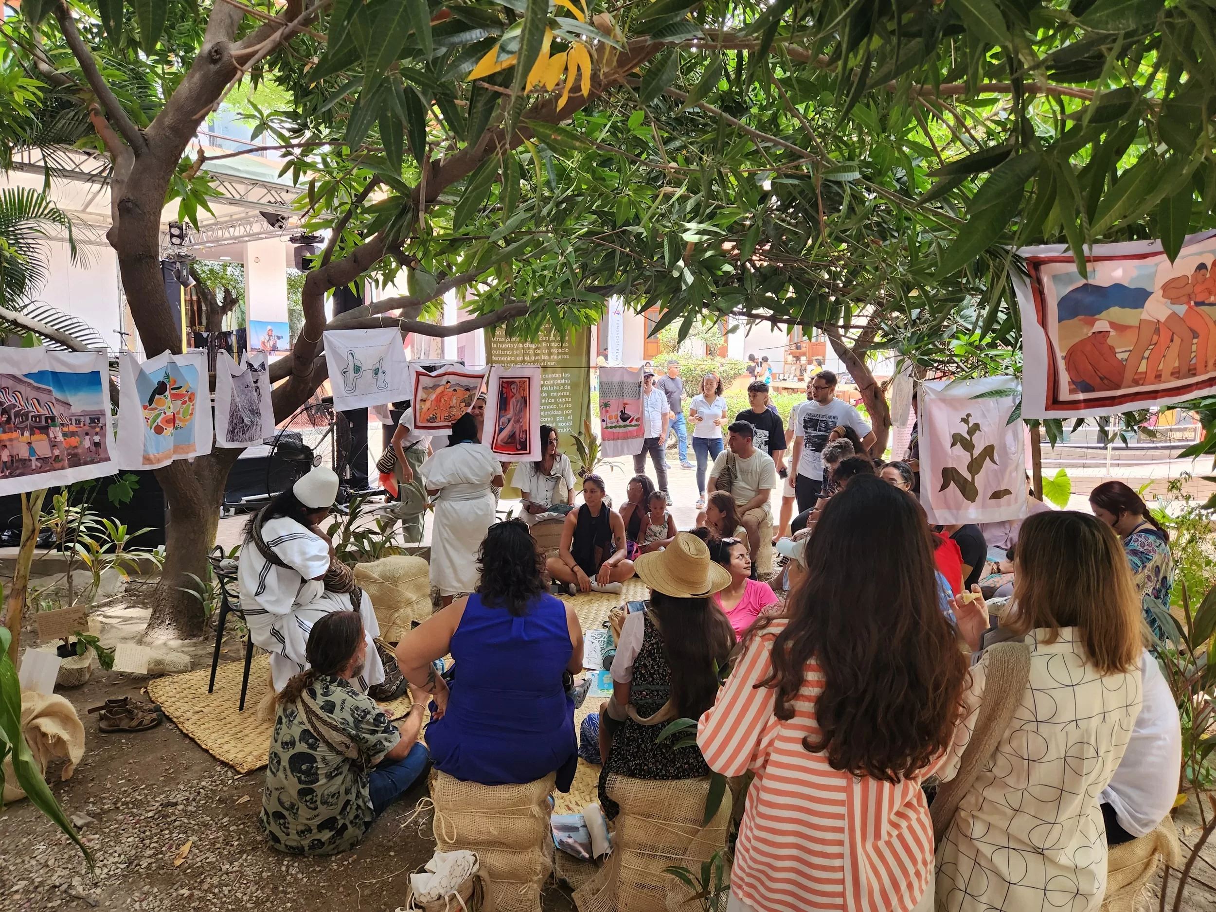 Grupo de personas debajo de un árbol participando de un taller de semillas
