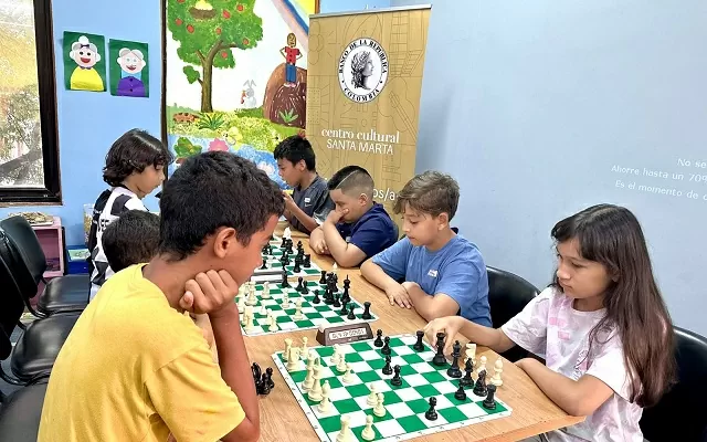 Grupo de niños y niñas jugando ajedrez 