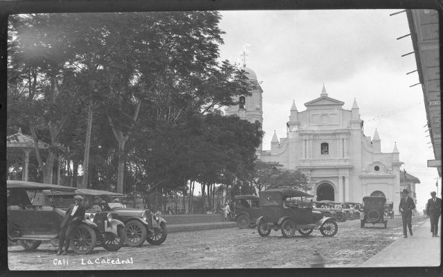 Foto de Cali plaza de caicedo antigua con coches de la época y personas con sombreros. Foto a blanco y negro 
