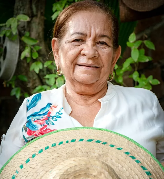 La artesana Alicia Bolívar sosteniendo un sombrero 