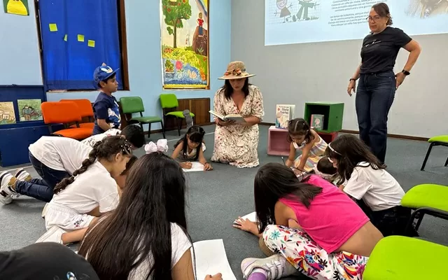 Grupo de niños y niñas alrededor de la tallerista