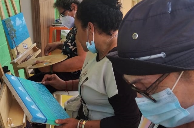 Mujeres providéncianas pintando paizaje marino