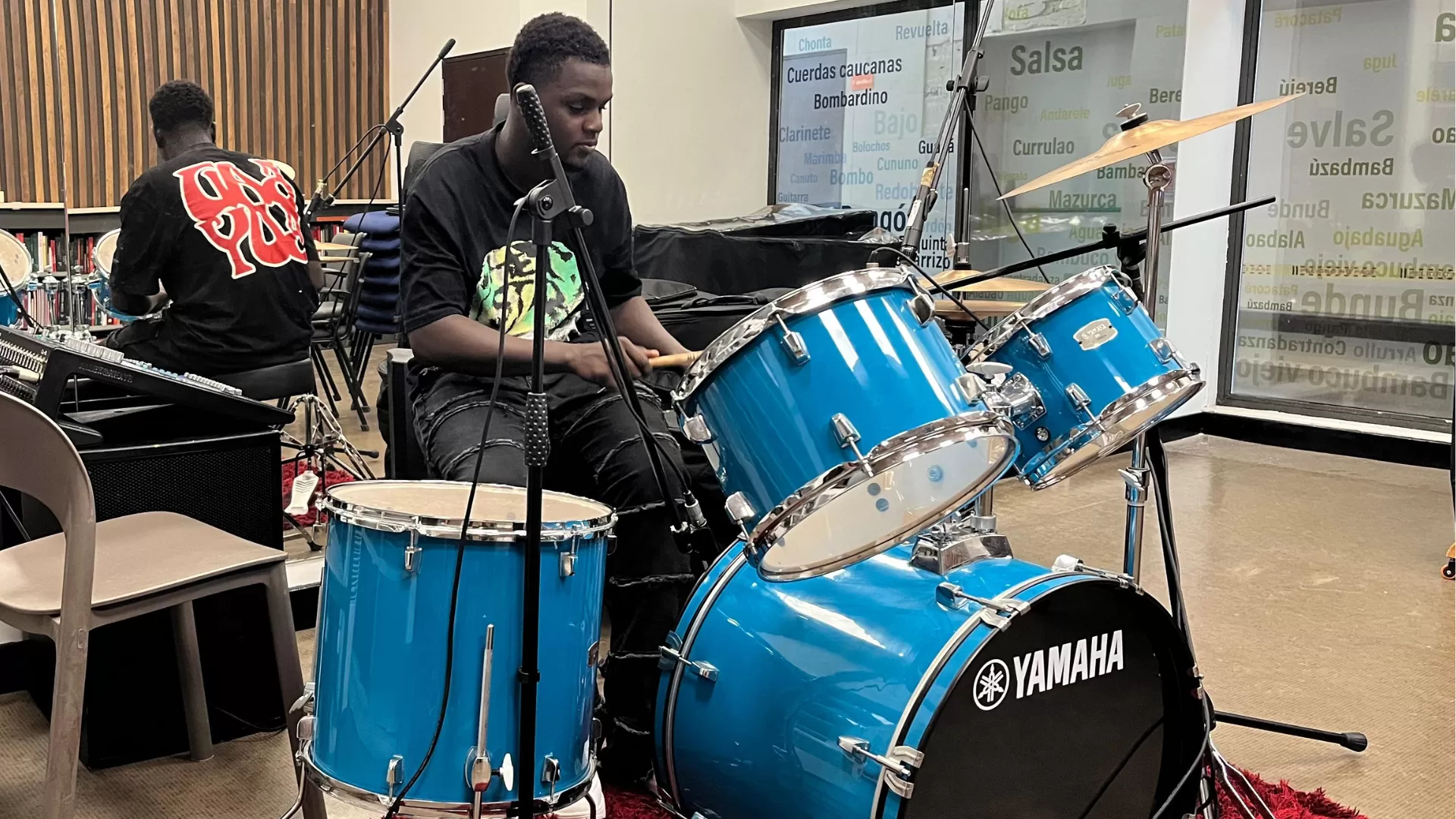 Joven tocando batería en la Sala de Prácticas Musicales del Centro Cultural de Buenaventura