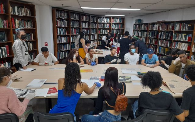 foto de personas asistentes a un taller al CDR de Cali un espacio lleno de libros y mesas para consulta bibliográfica e investigación 