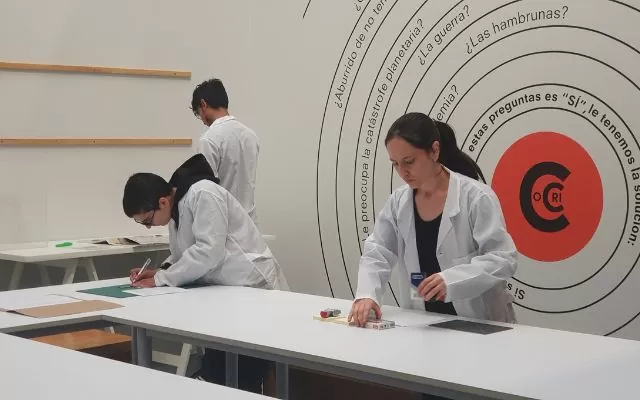 Fotografía donde se ven tres personas con batas blancas