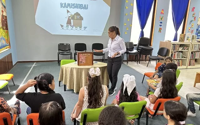 Grupo de niños viendo un pequeño teatro de kamishibai 