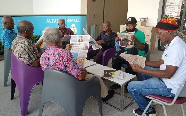 Participantes  del Club de periódicos leyendo en una de sus sesiones