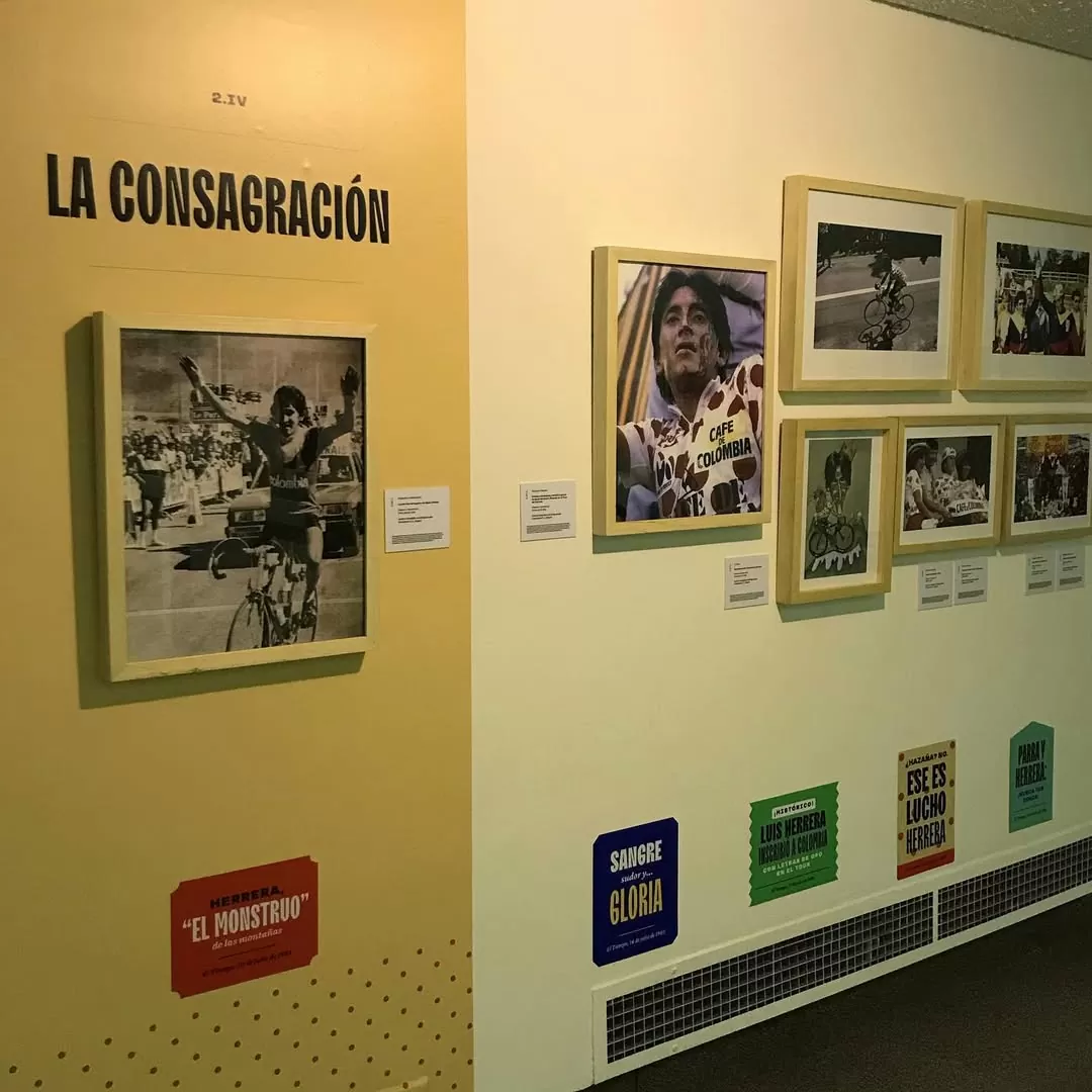 Fotografía de la exposición en su sección 'La consagración' al lado de una foto de la victoria de Lucho Herrera con su rostro ensangrentado vestido en la camiseta de mejor escalador en el Tour de Francia 1985