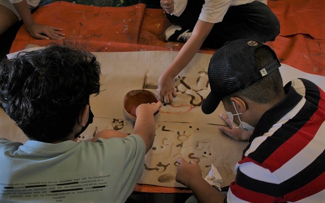 Detalle de los niños en el taller de pintura rupestre 