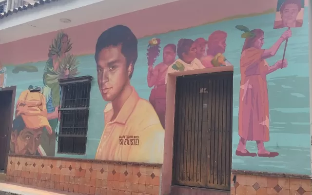En la foto se observa un mural colorido donde se muestran los rostros de algunas personas 