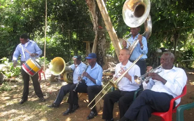 En la foto se encuentra un grupo de artistas tocando instrumentos de viento