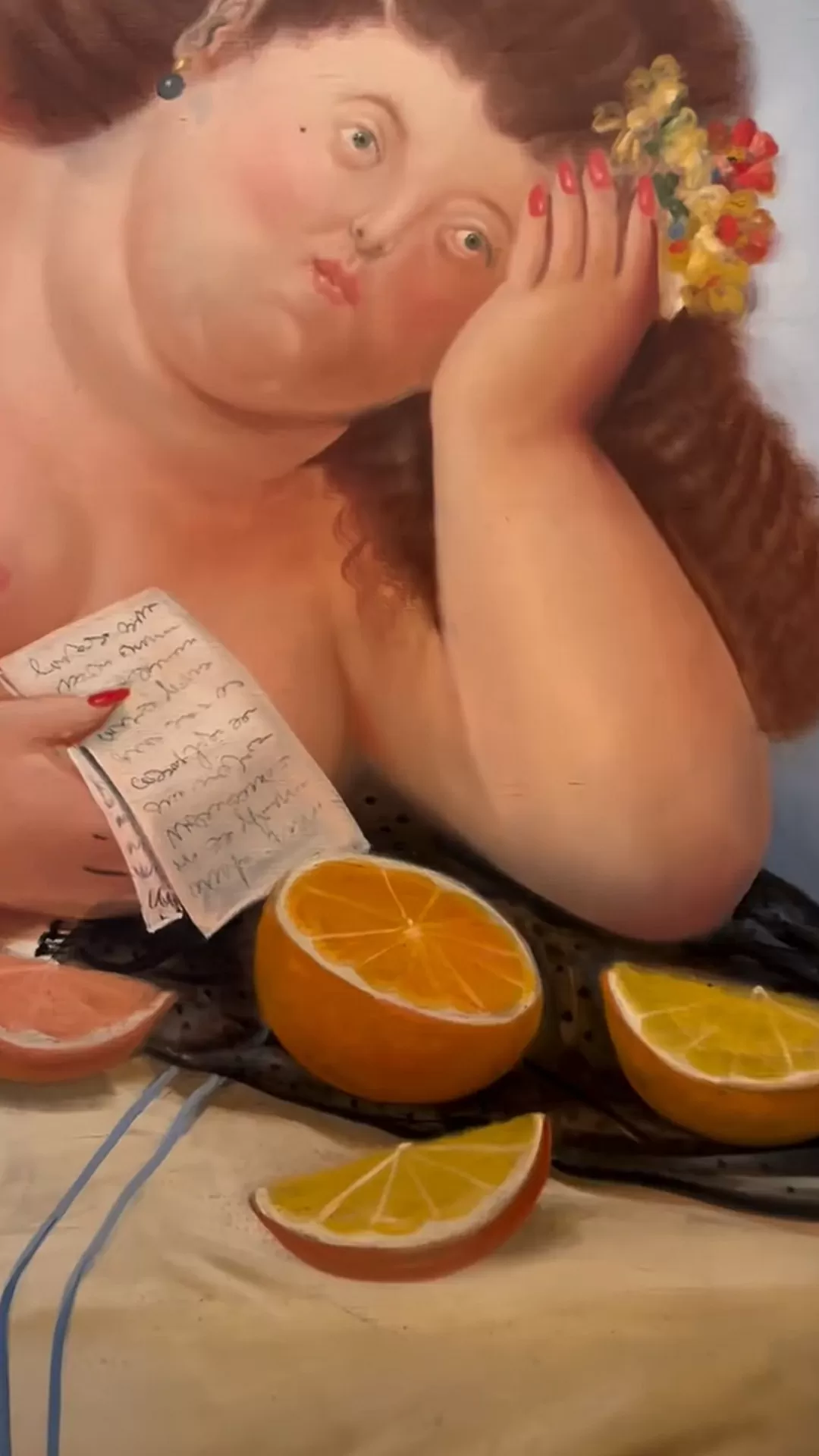 Mujer recostada, junto a  una naranja, en una pintura de Fernando Botero