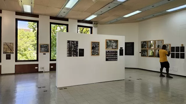 Una persona de camiseta amarilla visitando la exposición del fotógrafo Hernán Díaz 