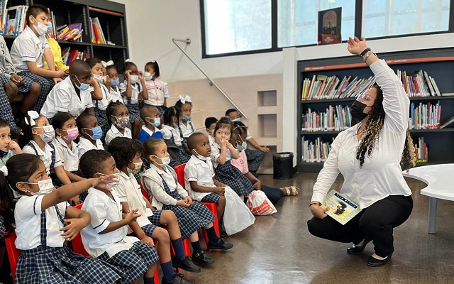 Mujer lee en voz alta a niños pequeños