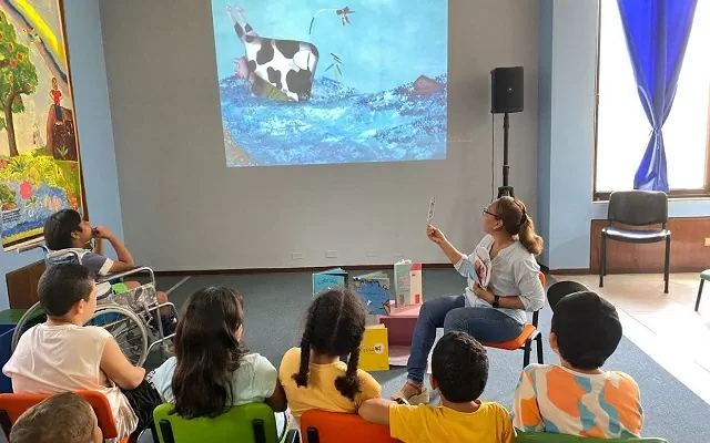Grupo de niños y niñas mirando hacia una pantalla 