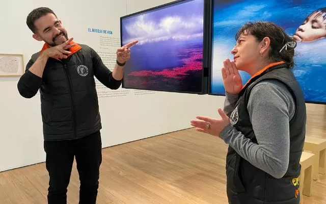 Un hombre y una mujer hablando en lengua de señas colombiana en una exposición