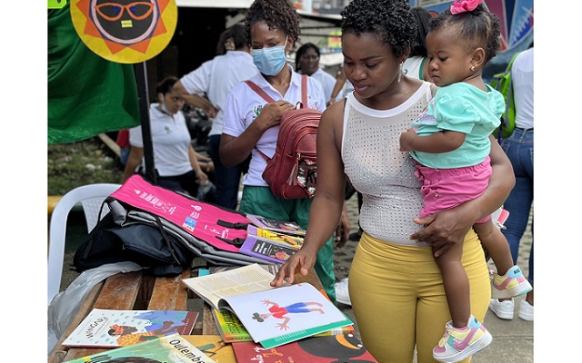 Mamá e hija observan un libro