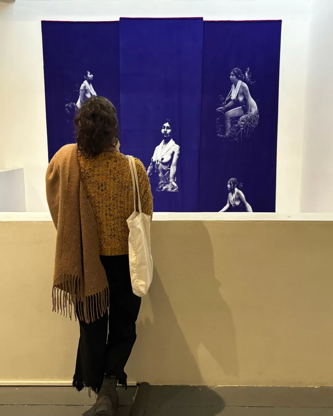 Joven observando una obra de la exposición Liturgias del Cuerpo