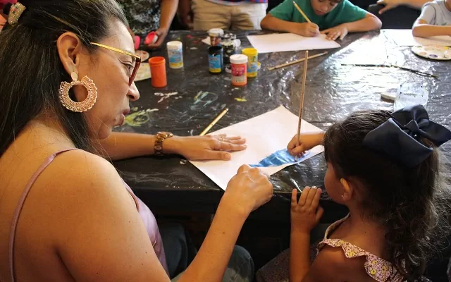 Una mujer dibujando con una niña