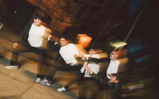 Imagen desenfocada, cinco artistas, posando al aire libre, usando camisa blanca 