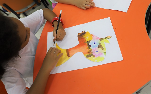 Niña pintando una silueta con tonos cálidos en la sala infantil del Centro Cultural Santa Marta 