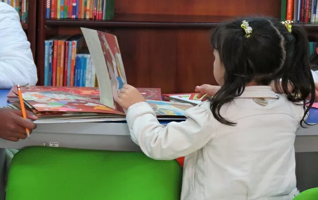 Niña leyendo en la sala infantil de la Agencia Cultural de Pasto