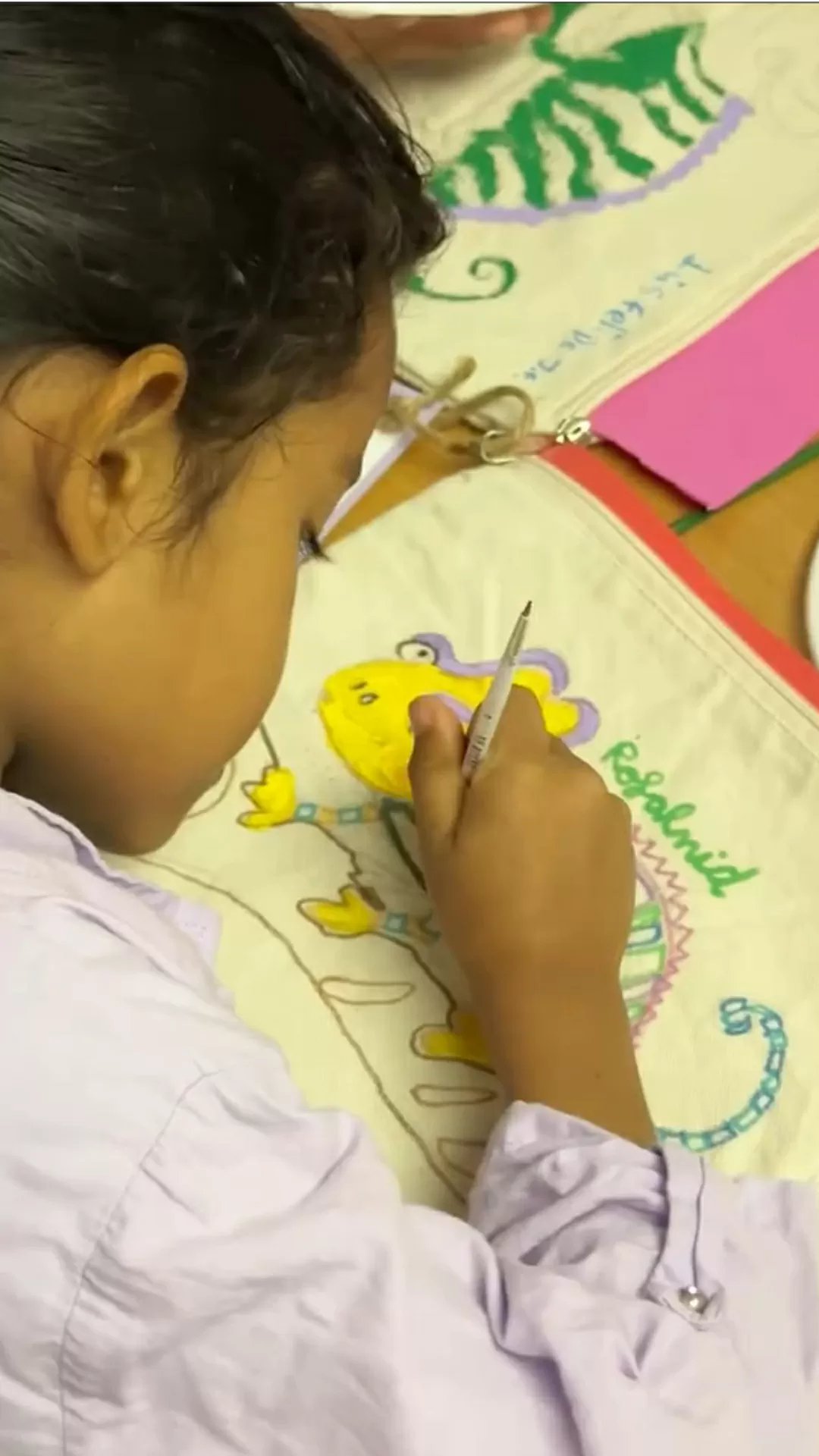 Niñas pintando una cartuchera en un taller de arte 