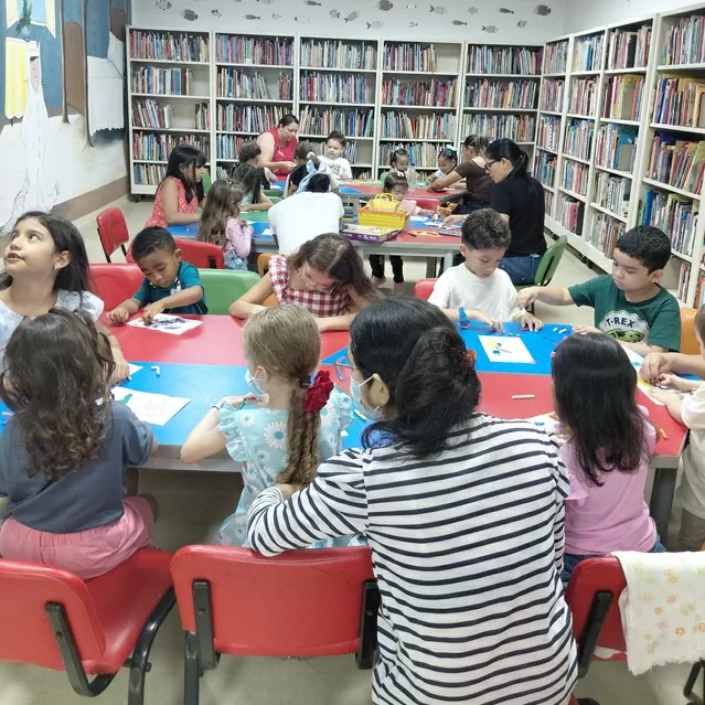 Niños y sus cuidadores participando de la medición de lectura y escritura