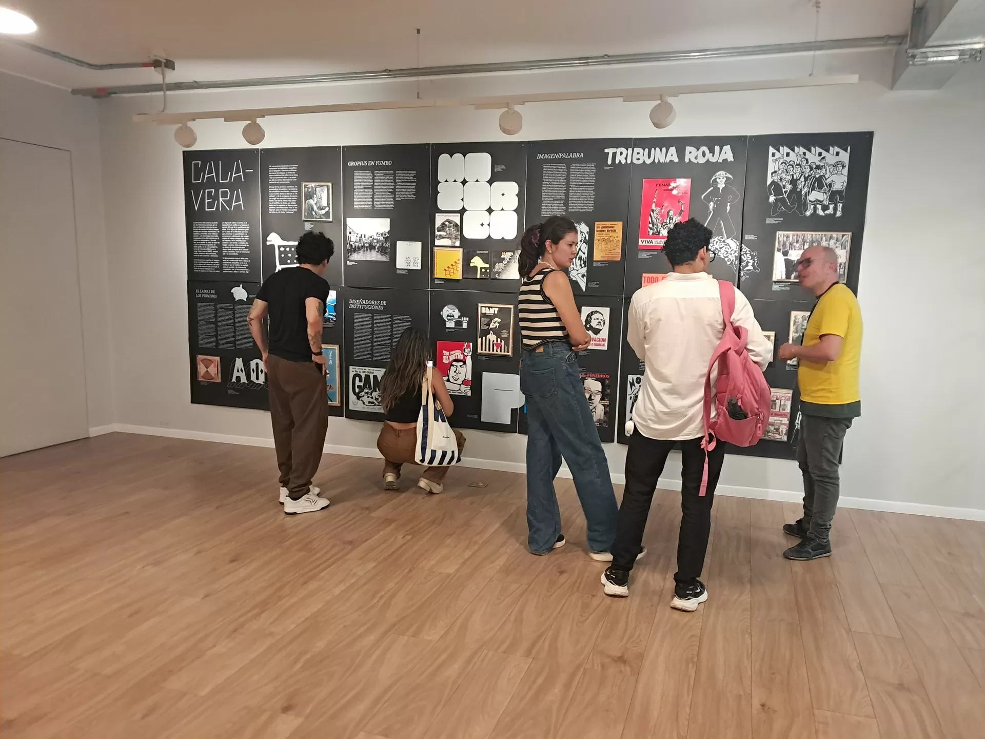 Público visitando la exposición Tipo, Lito, Calavera y conversando con el mediador