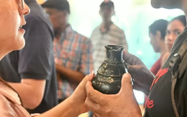 Dos personas ciegas tocan una cerámica de color negra 