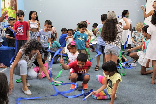 Grupo de niños moviendo cintas de colores verdes y azules 