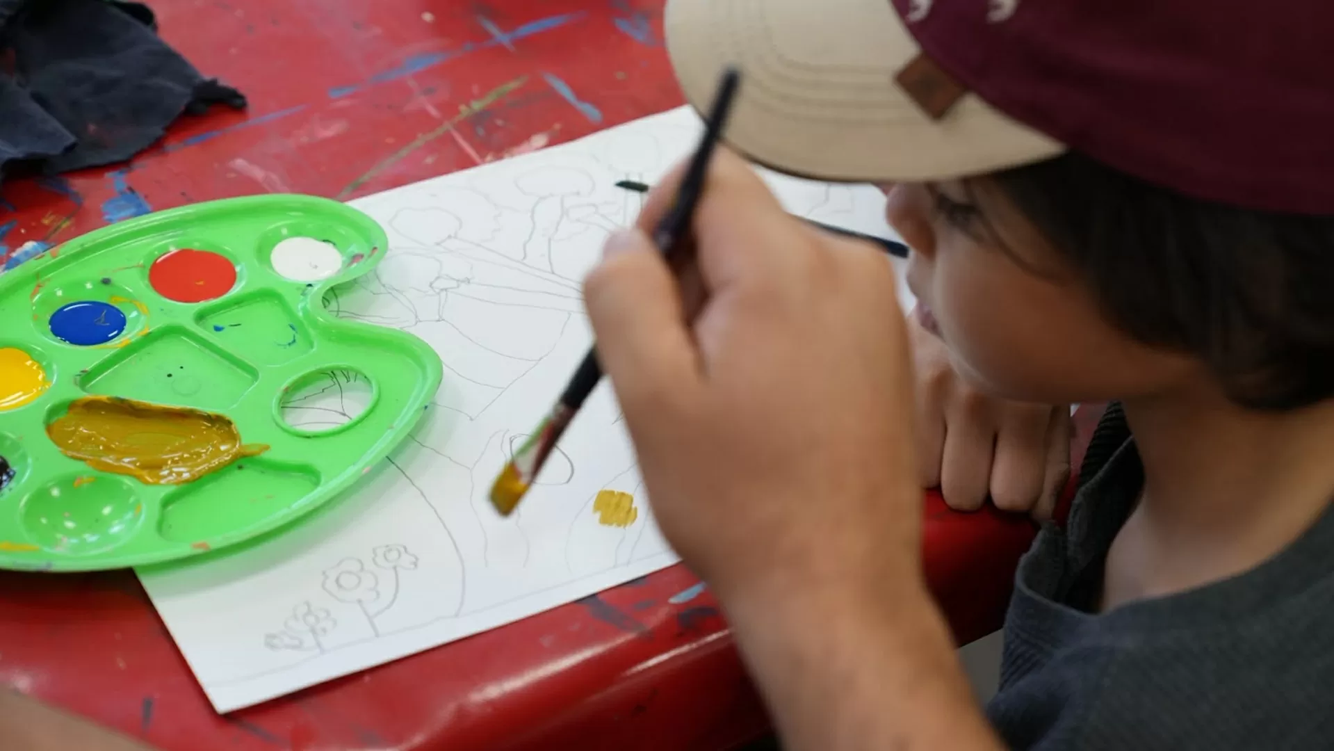 Niño pintando con su padre un dibujo en el taller de la sala infantil del Centro Cultural Santa Marta