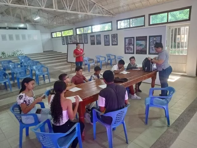 Grupo de personas alrededor de una mesa en una escuela rural 