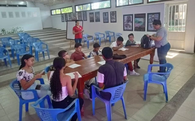 Grupo de personas alrededor de una mesa, participando del taller de escritura creativa 
