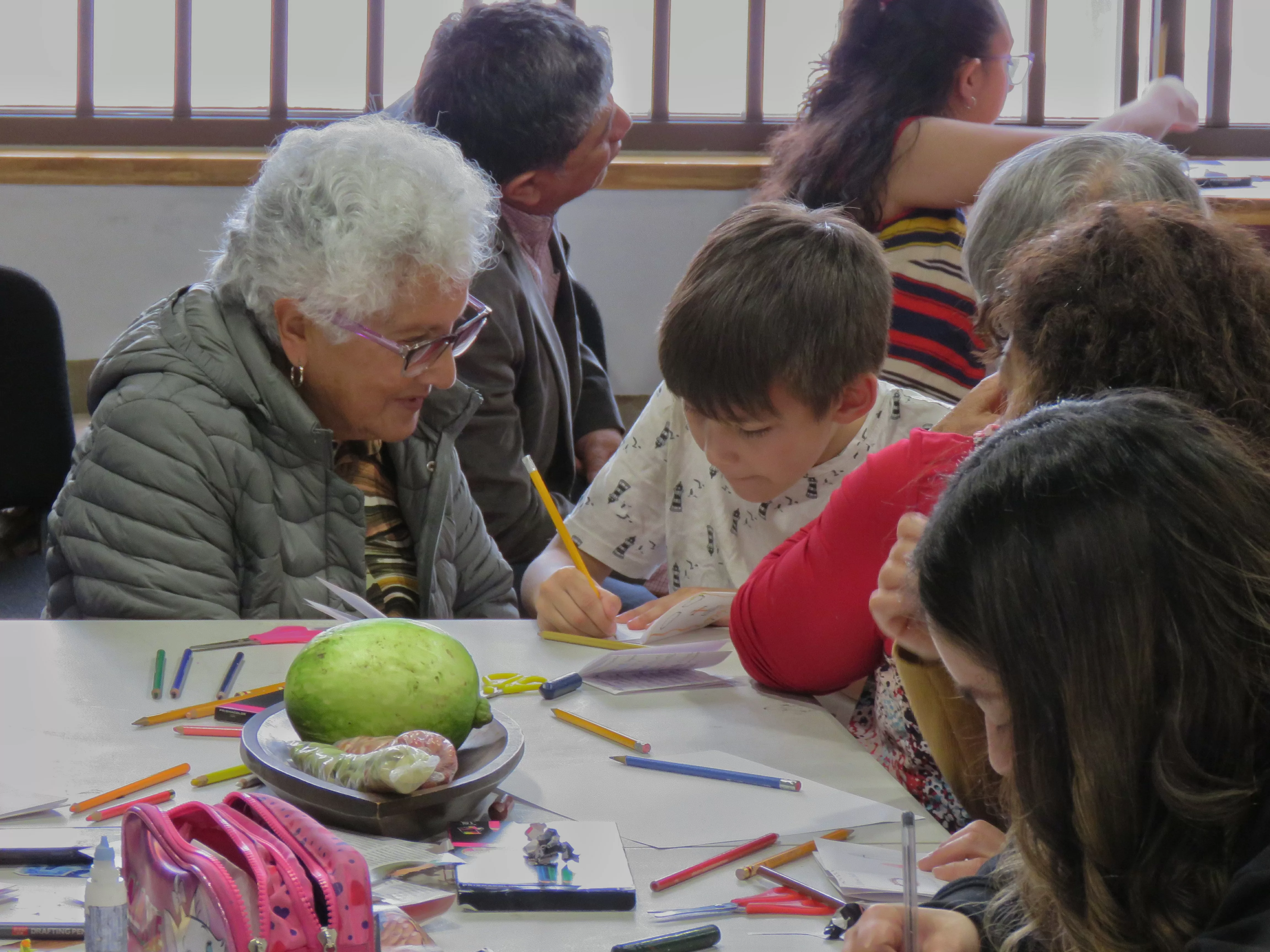 En la imagen encontramos a una persona adulto mayor y un niño interactuando