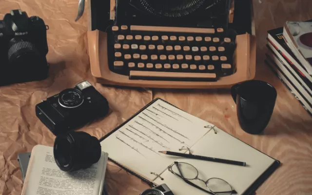 Máquina, cuaderno y cámara para periodistas