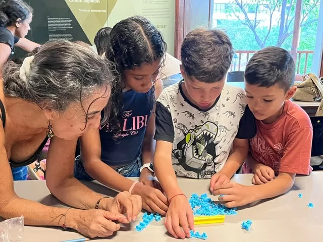 Grupo de niños seleccionando una piezas para construir una imprenta