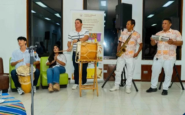 Cinco personas cantando y tocando tambor 