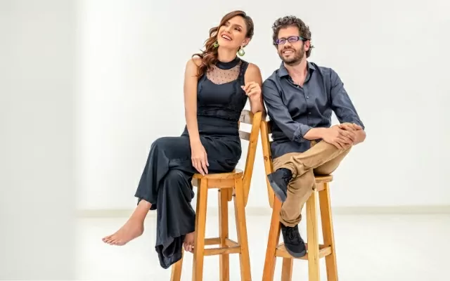 Victoria Sur y Nicolás Ospina sentados en dos butacas cafés observando al horizonte 