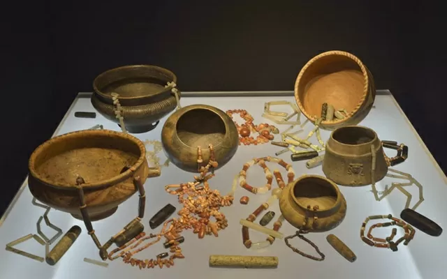 Grupo de vasijas de barro con cientos de cuentas de piedra para collar 