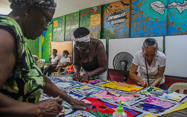 Fotografía de mujeres creando un mural tejido