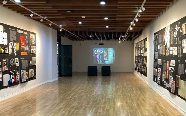 Pasillo con carteles a los lados y video proyectado en el centro