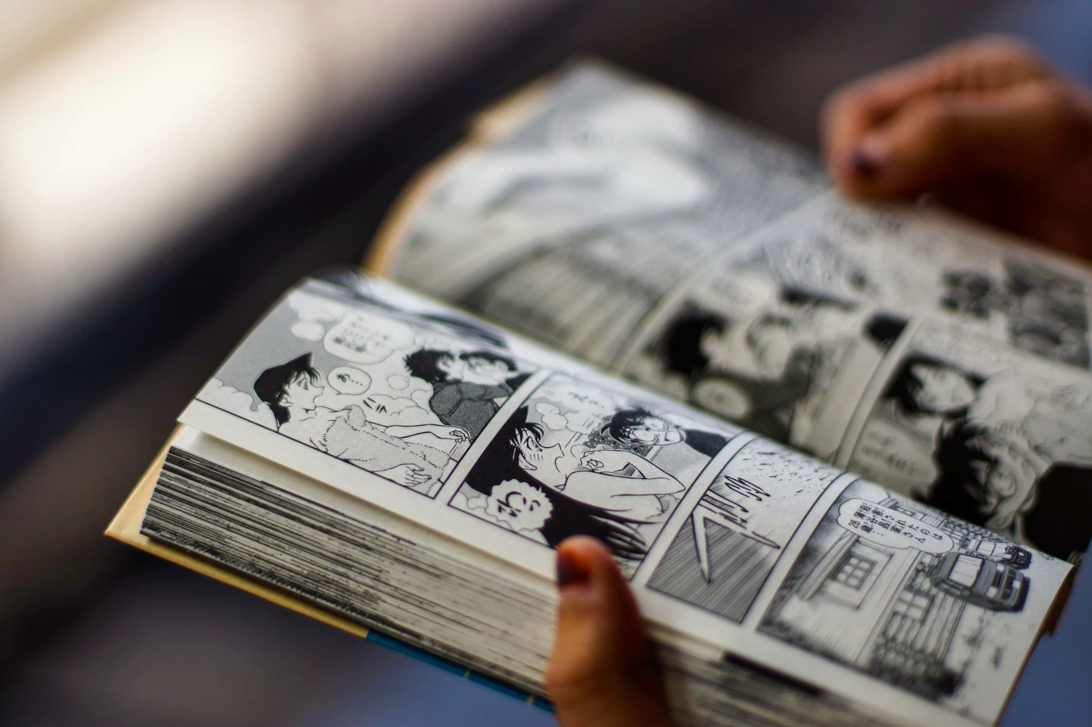 Plano cerrado de unas manos soteniendo un libro de manga japonés